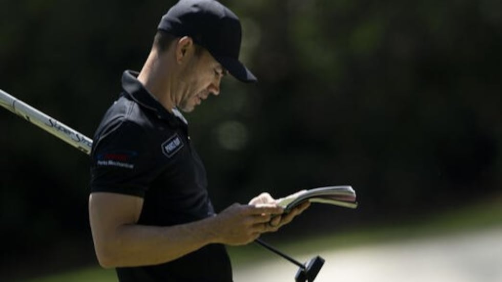 Camilo Villegas of Colombia looks at his yardage book on the No. 13 green during practice...