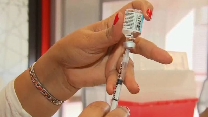 FILE PHOTO of medical personnel administering vaccine.